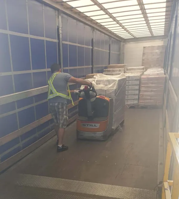 Voluntario descargando palés de alimentos de un camión del Banco de Alimentos en las instalaciones de la asociación en Getafe (Madrid)